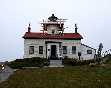 [The two-level tower sits above a white-washed, red-roofed single-story building at the top of the hill.]